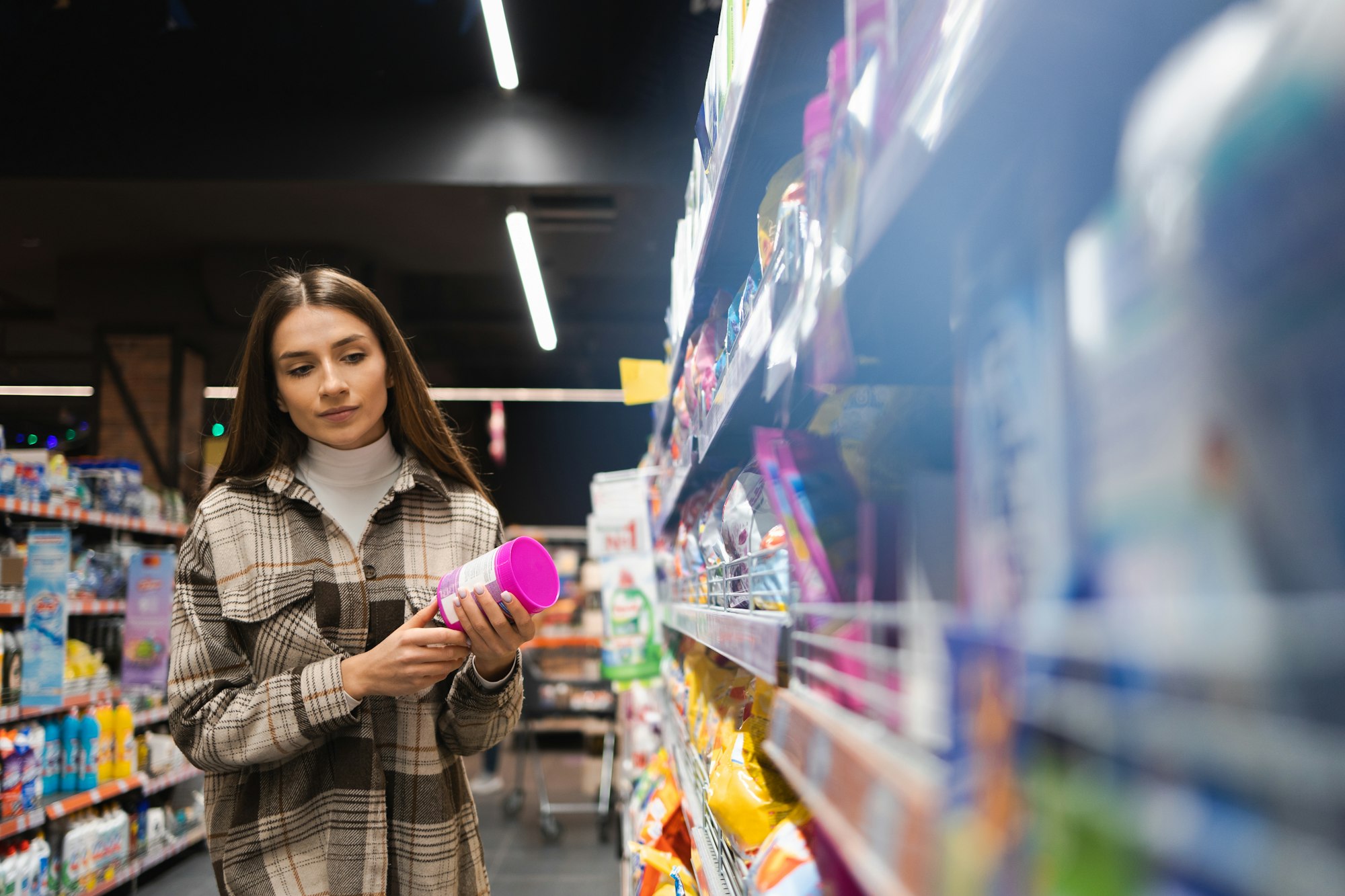 Young caucasian woman with packaging of cleaning agent in household